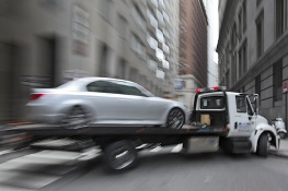 Car being towed by a flatbed truck