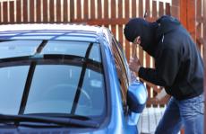 Masked man breaking into car