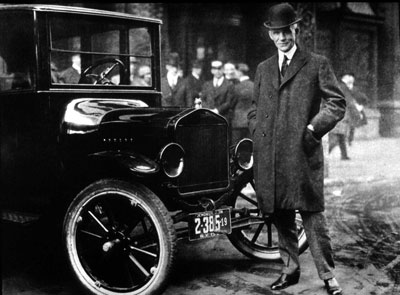 Henry Ford stands next to the Model T. Despite early successes of transportation modes such as railways, streetcars and subways, mass production of automobiles lowered prices, and more roads led many Americans to buy cars. See more ­classic car pictures.