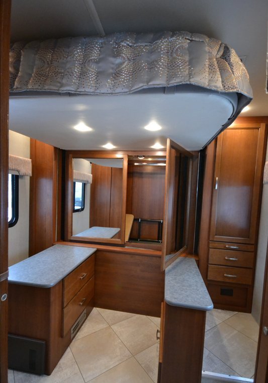 Raised bed reveals full wardrobe and two dressers 