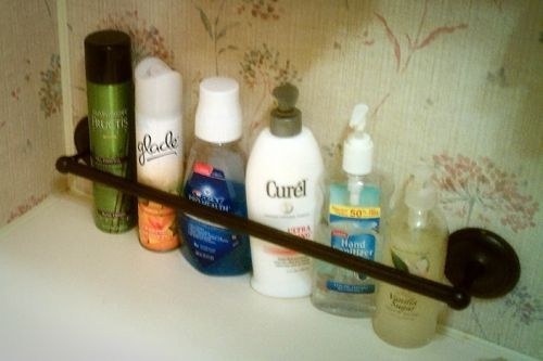 a towel rod is an easy hack to keep your bath products in place