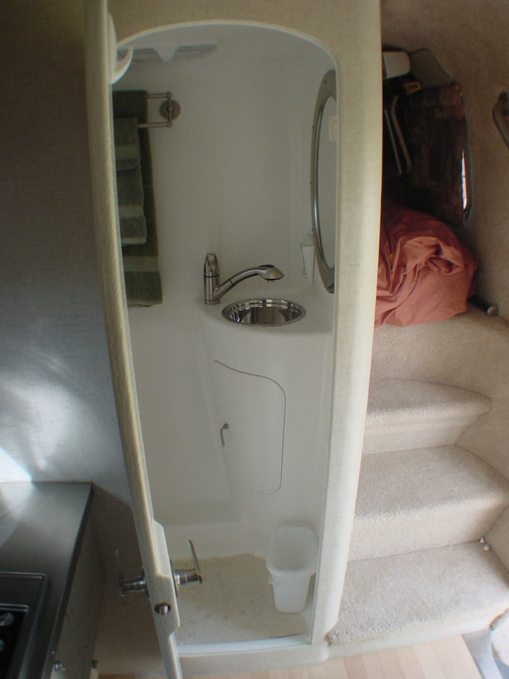 The-bathroom-also-features-a-stainless-steel-sink-and-a-full-fiberglass-shower-area