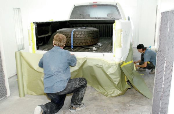 The truck then went to Lamb Fab for final bodywork and painting. As provided, most fiberglass panels have some waviness in them, especially long bedsides. Joe Dunphy and Justin Miller sanded out the high spots on the bedsides and added thin filler where needed to get the fiberglass looking straighter. Then it was time to pull the truck in the paint booth for primer. A really good paint shop will mask a vehicle to the floor like this to prevent overspray from getting anywhere on the vehicle.