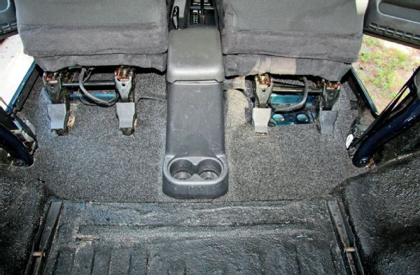 To secure the rear portion of the BedRug behind the front seats, you will need to remove the two bolts that attach the rear portion of the center console. Doing so will allow you to more easily fit the BedRug in place.