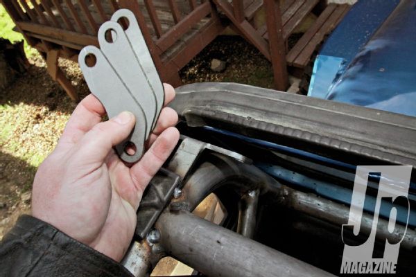 The TJ top header fastens to the header of the windshield frame with latches rather than the plastic in the groove of YJs. So, it might look odd to you older Jeep owners, but the space between the windshield and the front header bar of the ’cage is deliberate. However, we still had to cut about 11⁄2 inches off of our top levers to get them to clear the tube. Also note the location of the included tabs and tab spacers that Synergy includes with the kit. In a YJ, this is now all that will hold our windshield up when we have the top off.