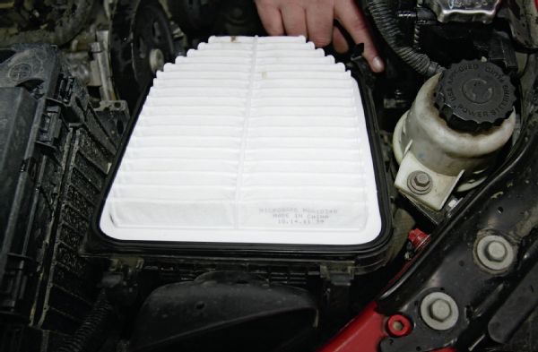 Since you’re already up there, it would be a good idea to go ahead and change the air filter now. Undo the top cover by popping the four clips loose and replacing the filter with a new one, making sure it is well seated in the air box. One of the great mysteries of the world is the placement of the front-right clip. If you have large clumsy hands like me, a long screwdriver may help you to put that clip back in place.