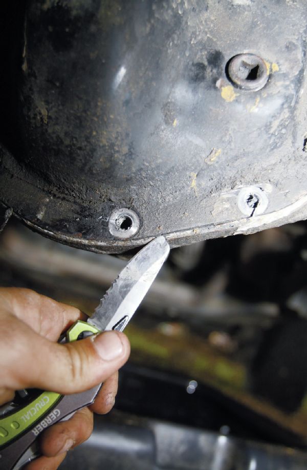 If you find it necessary to pull the cover, drain the oil first, and then use a 13mm socket to pull the bolts. Use a thin knife blade, putty knife, or scraper to break the seal on the gasket. Do not force the cover off, as you can bend it enough to cause a leak. Just continue to work whatever tool you are using around the cover until it pops off.