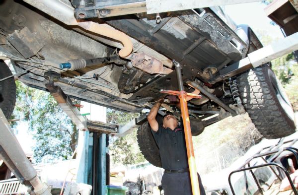 While it is possible to do this install by leaving the T-case in the Jeep, we opted to pull the entire thing out of the Jeep for this install. However, we have TnT Custom’s coil conversion on this Jeep so that makes removal a little more difficult. The belly skid comes apart in several sections, so the thought was that if we just pulled the rear portion, there would be enough space to work.