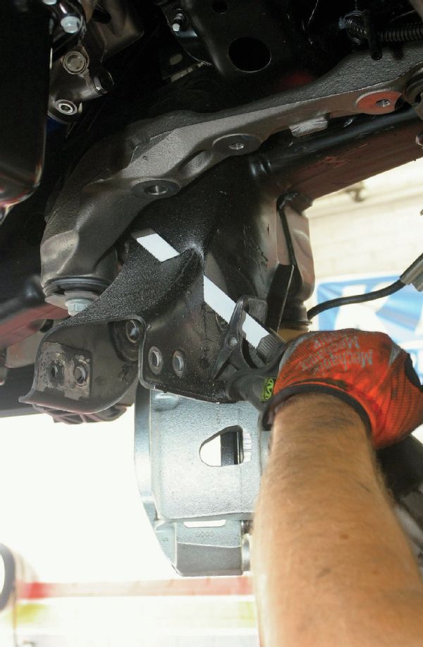 A reciprocating saw is used to modify the rear lower control arm frame pockets.