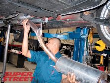 0703_130_19z+2006_honda_civic_si+guy_removing_exhaust