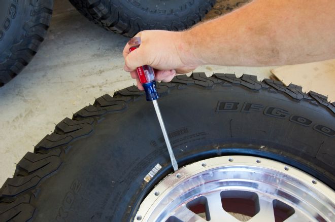 Wedging X103 Xtreme Beadlock Wheel Into Place With Screwdriver